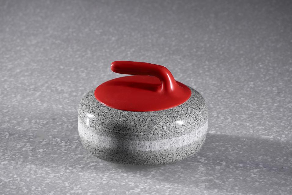 Grauer Curlingstein mit rotem Griff auf einer schimmernden Oberfläche.