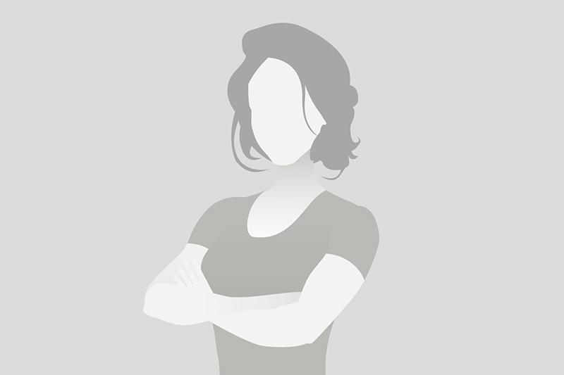 Silhouette einer Person mit schulterlangen Haaren, die die Arme verschränkt hat, vor grauem Hintergrund.